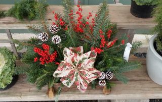 holiday evergreen centerpiece with bow and berries