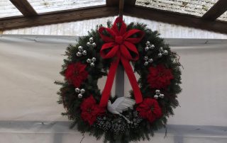 Christmas wreath with dove, silver baubles and red bow